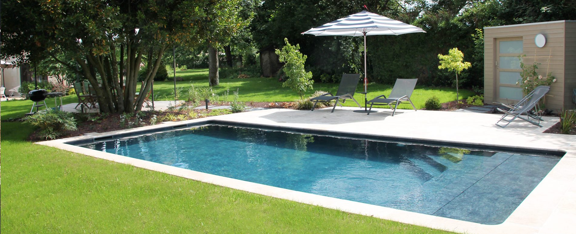 piscine paysagée avec terrasse en pierre et abri de jardin